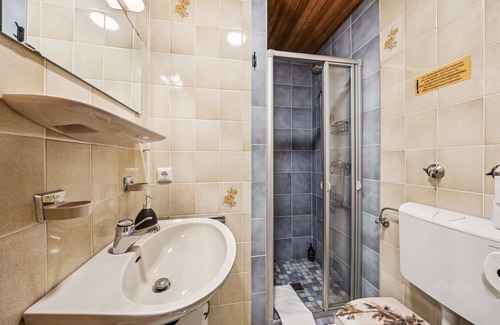 Wilhelmshaven Hotel | Cozy single room, flat-screen TV, and modern bathroom with shower. Ideal for singles and short stays – enjoy a relaxed atmosphere with warm wood accents and coastal charm.