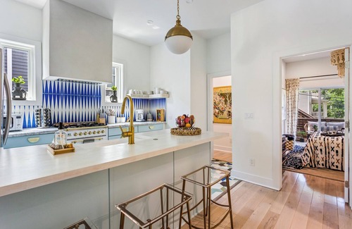 Midtown Apartment | Enjoy colorful vibes, velvet furniture, and a showstopper kitchen with funky blue hand-dyed tiles.