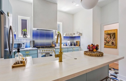 Midtown Apartment | Enjoy colorful vibes, velvet furniture, and a showstopper kitchen with funky blue hand-dyed tiles.