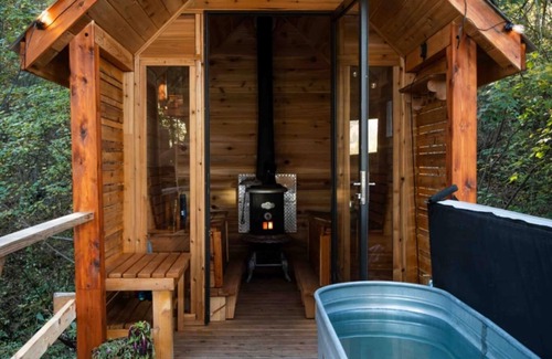 Armstrong House | Glamping in the woods with this Treehouse built in between 2 big alive Fir Tree