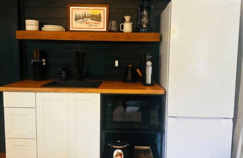 Mill Spring RV Rental | The Dogwood - Glamping tent with 1 King bed for 2 adults. En suite bathroom, kitchenette, and open porch.