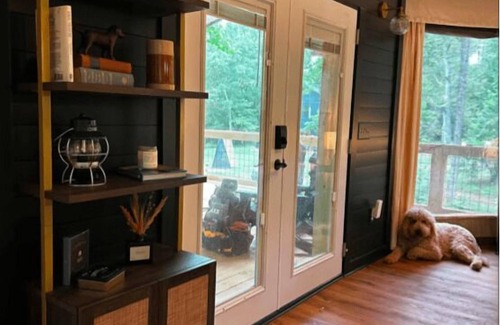 Mill Spring RV Rental | The Dogwood - Glamping tent with 1 King bed for 2 adults. En suite bathroom, kitchenette, and open porch.