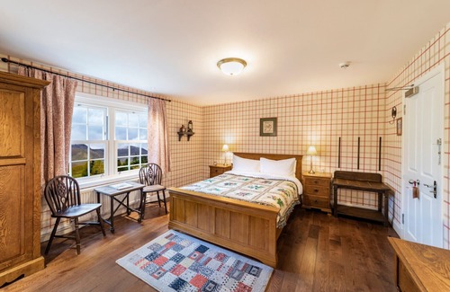 Shiel Bridge Bed & Breakfast | The wooden floors, vintage furniture, and tartan accents create a comfy room
