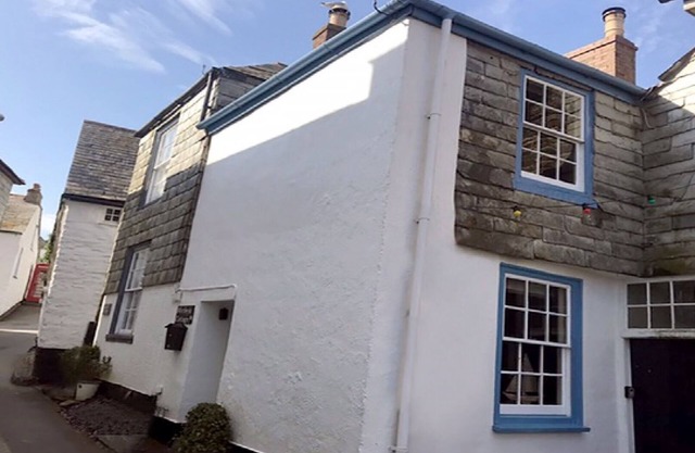 A charming fisherman's cottage in picturesque Port Isaac harbour .