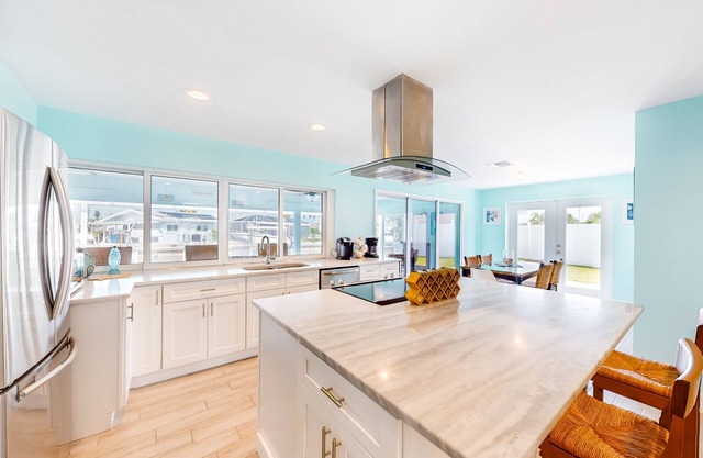 Canal-front home with heated saltwater pool, dock, grill, & covered patio
