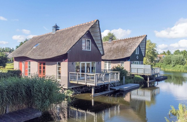 Detached 8-person fisherman's villa with a patio above the water and a private jetty at Beach Resort Makkum on the IJsselmeer.