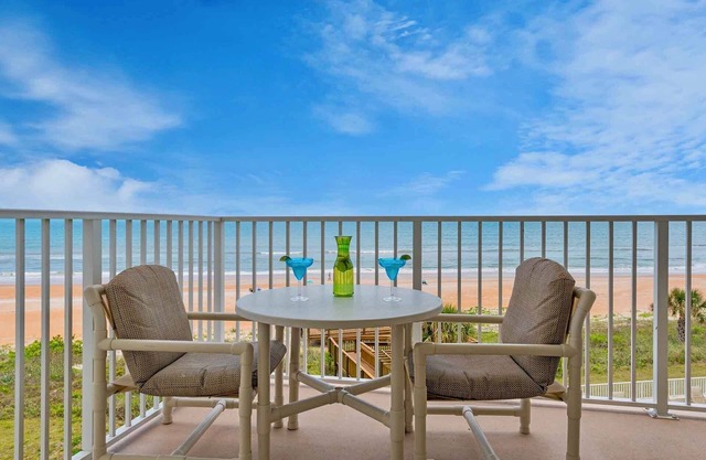 Direct oceanfront condo with a private balcony, heated beachfront pool, and garage