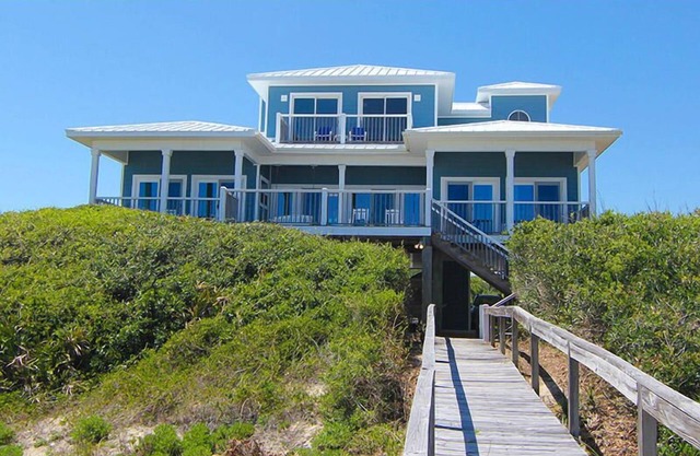 LEAVE YOUR WORRIES SURFSIDE. Take the private boardwalk and you're only steps from the beach.
