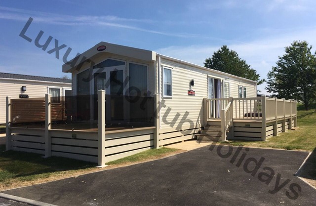 Luxury mini lodge at Tattershall Lakes, with outdoor decking and sunken hot tub.