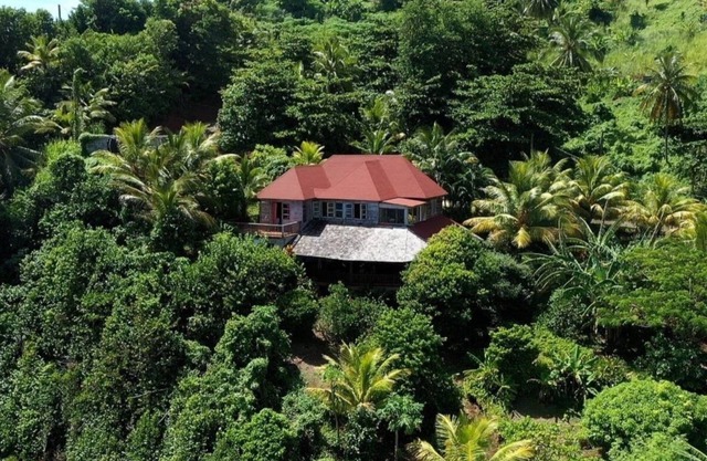 Private wooden villa with stunning ocean views, in an enchanting garden setting.