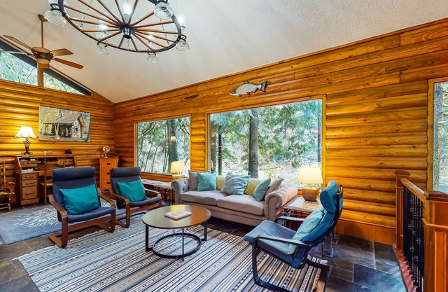 Spacious riverfront lodge with beach access, private hot tub & forest views