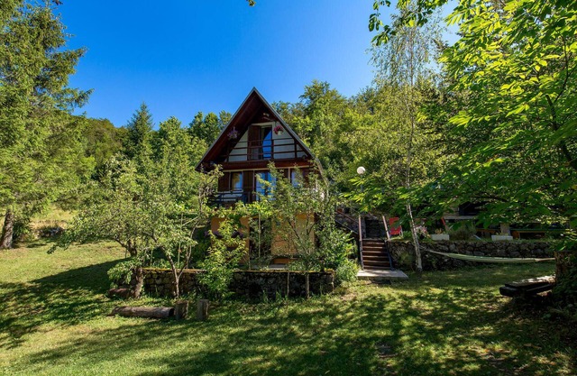 Surrounded by pine trees is this small cottage.