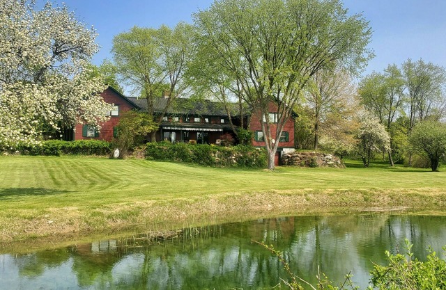 The Old Orchard Home surrounded by a small apple orchard, large meadows, and a private pond