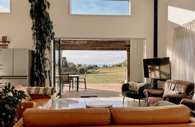 The open-plan kitchen, dining and lounge area is the heart of the home, perfect for sharing a meal, curling up with a good book, or simply watching the weather roll in through the floor-to-ceiling windows.