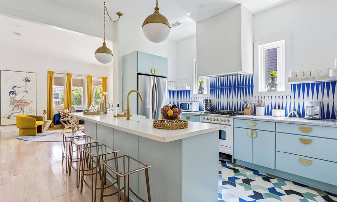 Midtown Apartment | Enjoy colorful vibes, velvet furniture, and a showstopper kitchen with funky blue hand-dyed tiles.