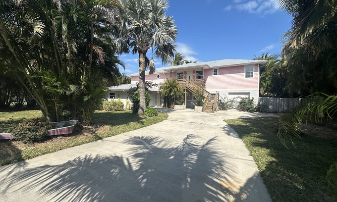 Fort Pierce House | Nestled amidst lush greenery The 5 Bedroom Pink House offers a serene getaway.
