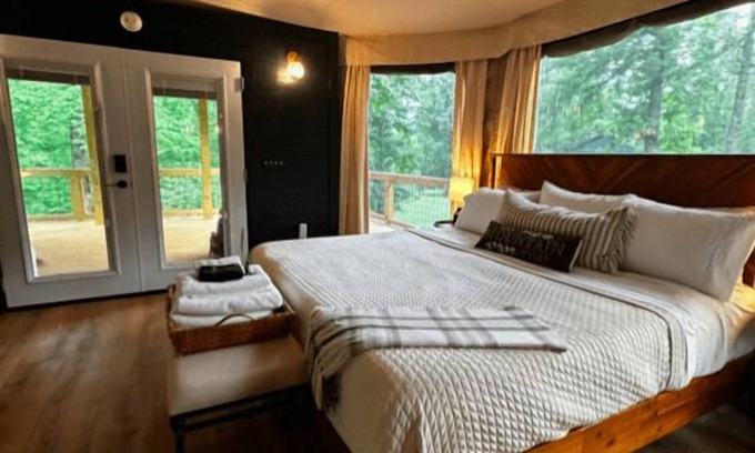 Mill Spring RV Rental | The Dogwood - Glamping tent with 1 King bed for 2 adults. En suite bathroom, kitchenette, and open porch.