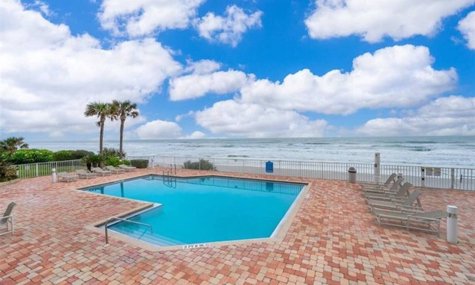 Ponce Inlet Condo | This stunning oceanfront 2BR condo in peaceful Ponce Inlet offers breathtaking beach views. Relax on the wraparound balcony with your morning coffee as pelicans glide by and dolphins surface in the waves below.