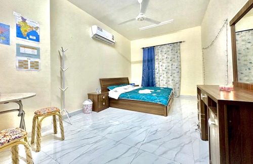 Seeb Apartment | Bedroom with an attached bathroom, shared kitchen in area with everything around